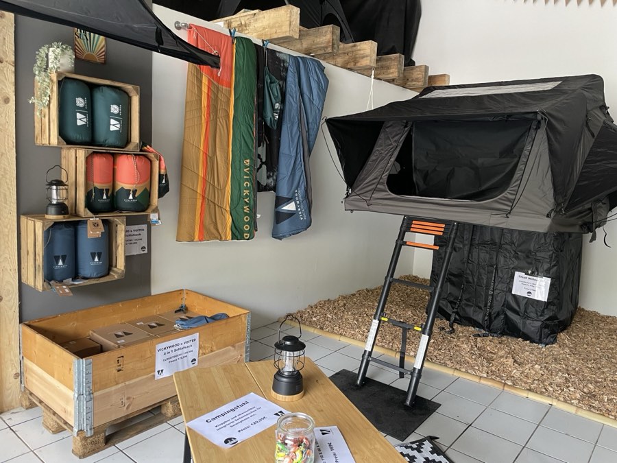Showroom mit aufgebautem Dachzelt, Holzregalen und Zubehör